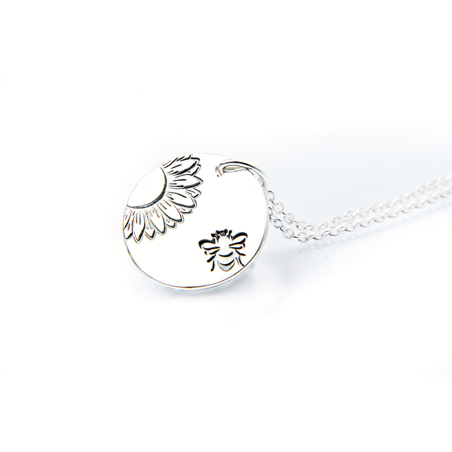 Silver disc pendant with sunflower and bee stamped design. Complimentary sterling silver chain.