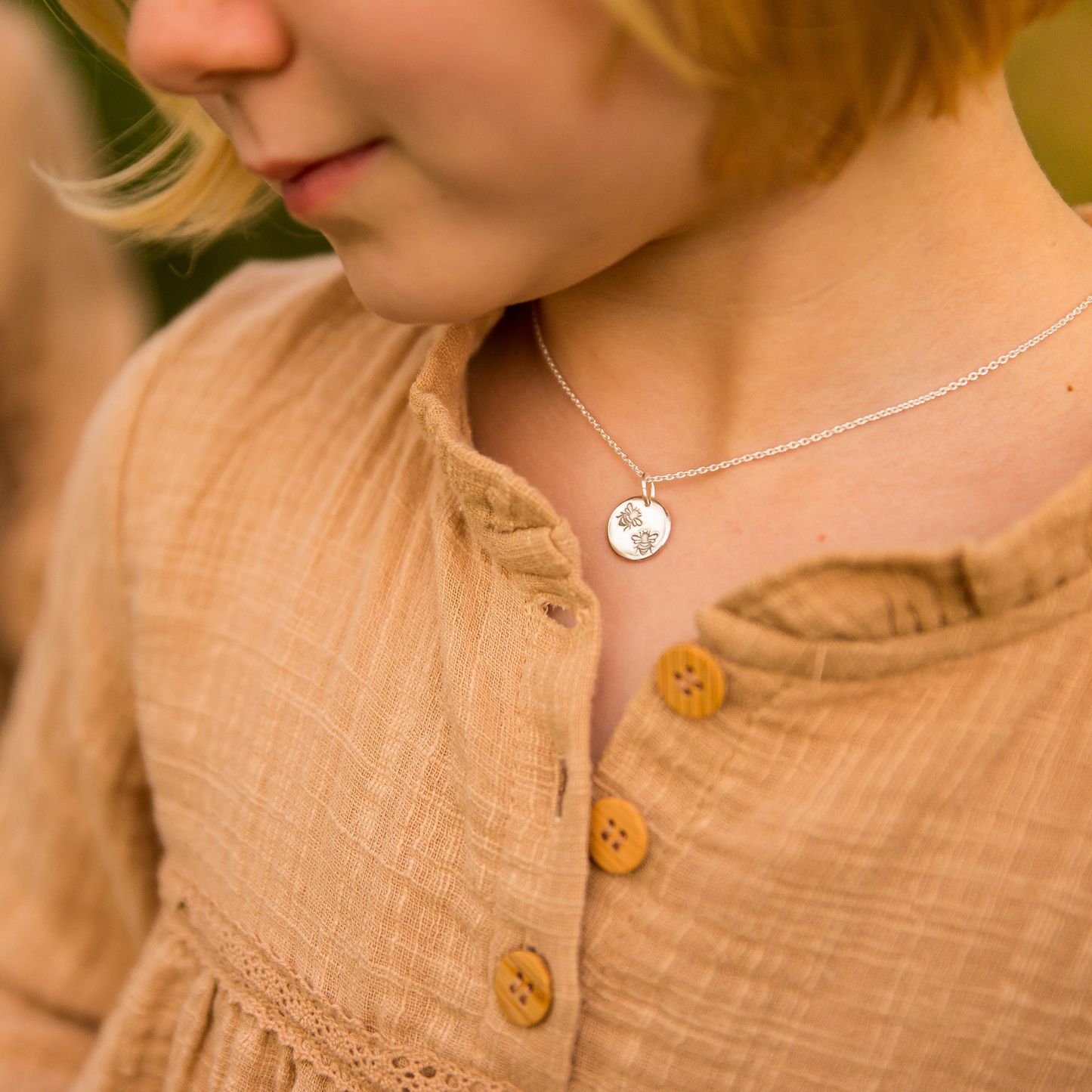 Bee necklace being worn.